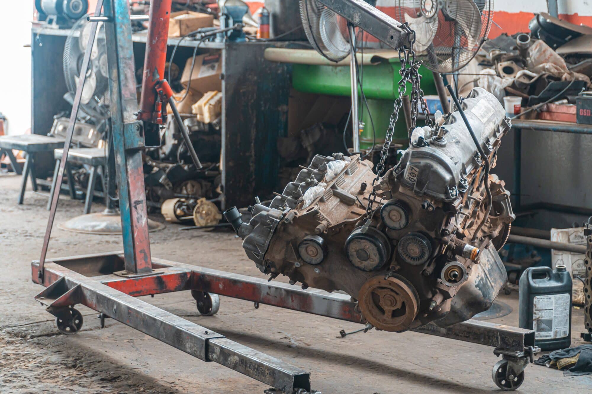 Un motor lleno de carbonilla se sitúa en una zona de trabajo de un taller mecánico para limpiarlo y repararlo.