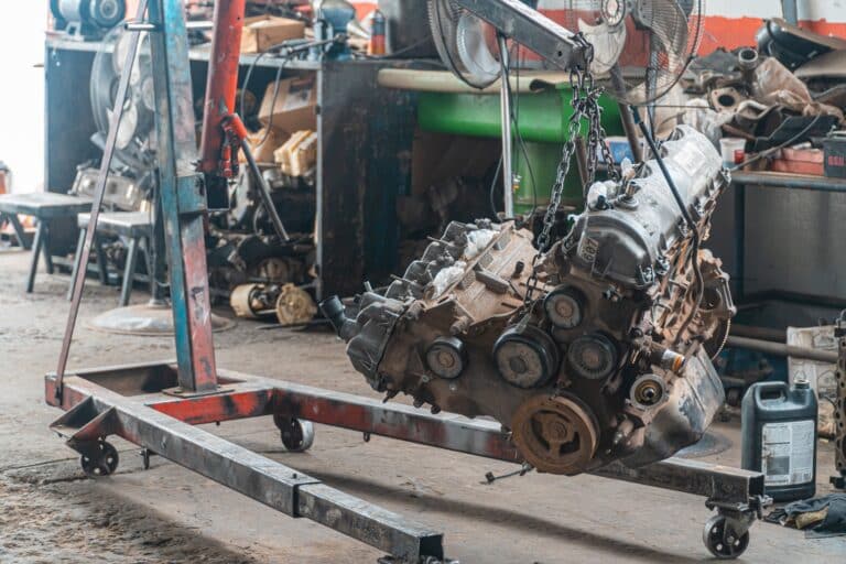 Un motor lleno de carbonilla se sitúa en una zona de trabajo de un taller mecánico para limpiarlo y repararlo.